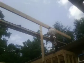 Carpenter setting a ridge beam over a new addition frame — Ice Dam Removal by Roofing Brothers in Allenhurst